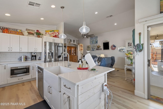 kitchen featuring light countertops, light wood-type flooring, visible vents, and stainless steel appliances