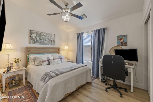 bedroom featuring visible vents, lofted ceiling, a ceiling fan, and light wood finished floors