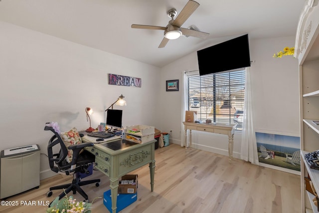 office space featuring baseboards, a ceiling fan, light wood-style floors, and vaulted ceiling