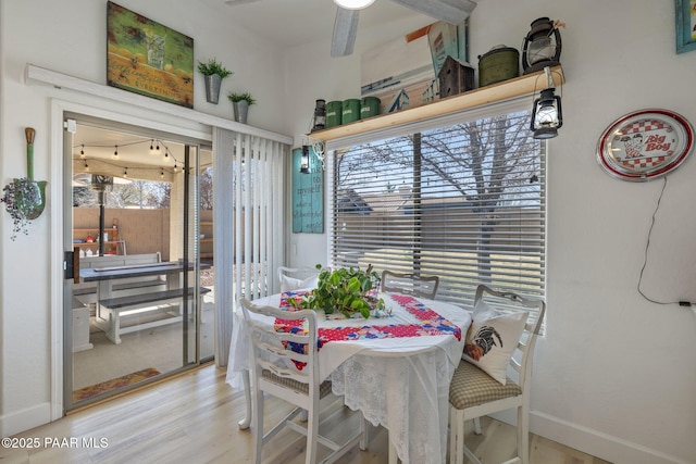 dining space with wood finished floors, baseboards, and ceiling fan