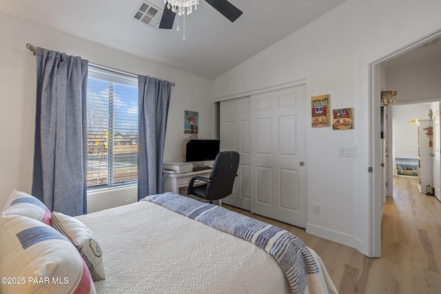 bedroom featuring visible vents, ceiling fan, light wood-type flooring, lofted ceiling, and a closet