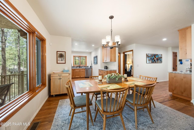 dining room with baseboards, a chandelier, wood finished floors, and visible vents