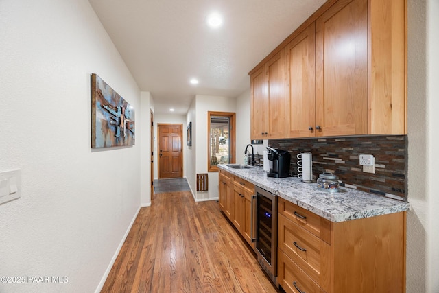 bar featuring recessed lighting, beverage cooler, baseboards, light wood-style floors, and tasteful backsplash