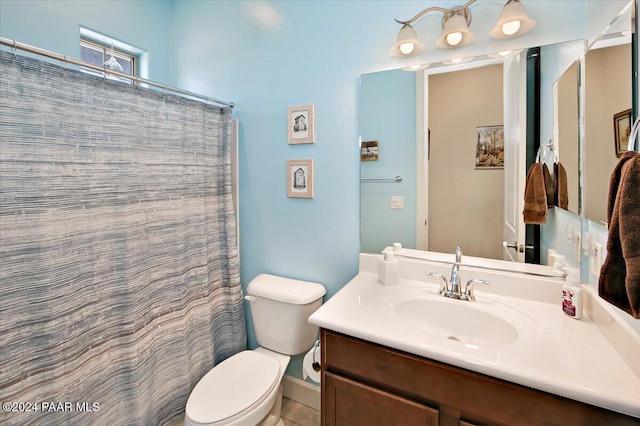 bathroom featuring tile patterned floors, vanity, toilet, and walk in shower