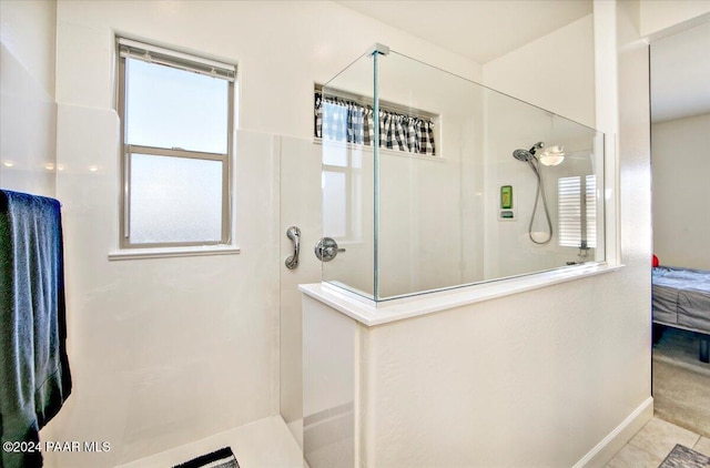 bathroom featuring a shower, tile patterned floors, and a healthy amount of sunlight