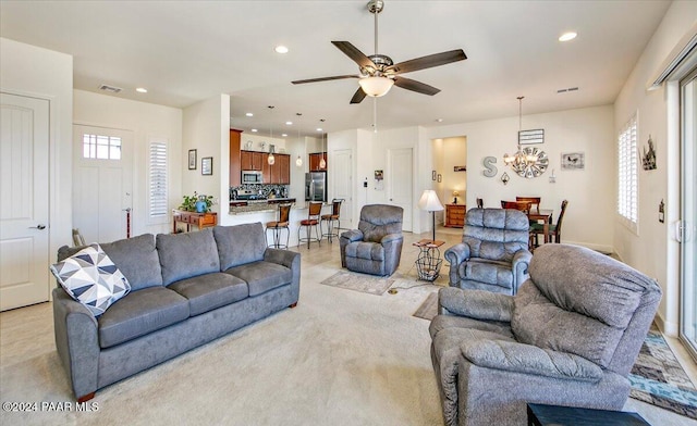 living room featuring ceiling fan with notable chandelier