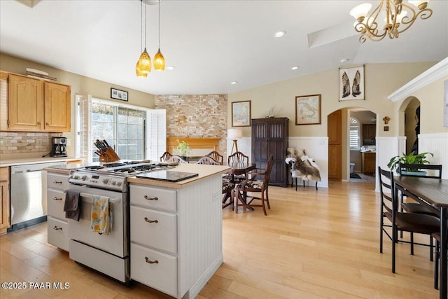 kitchen featuring stainless steel appliances, a kitchen island, pendant lighting, and light wood-type flooring