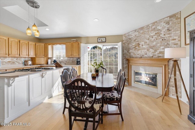 dining space featuring a premium fireplace and light wood-type flooring