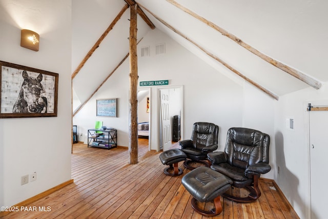 living area featuring hardwood / wood-style flooring, beamed ceiling, and high vaulted ceiling