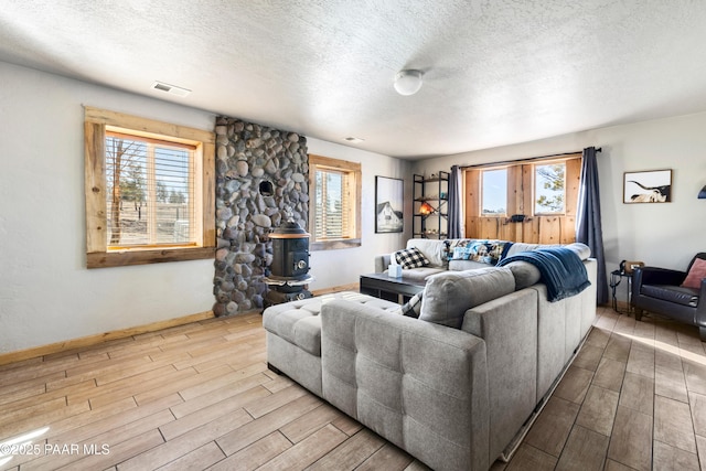 living room with a wood stove and a textured ceiling