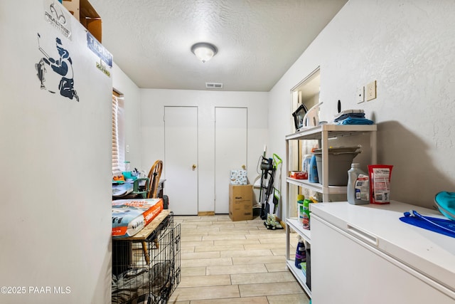 clothes washing area with a textured ceiling