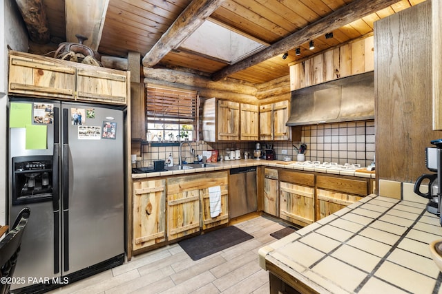 kitchen featuring beamed ceiling, appliances with stainless steel finishes, tile counters, and wooden ceiling