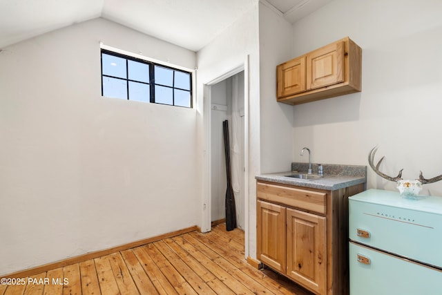 kitchen with sink, refrigerator, lofted ceiling, and light wood-type flooring