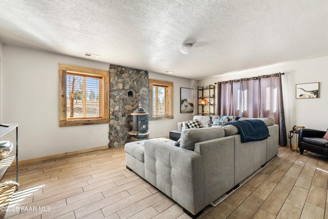 living room featuring a textured ceiling and a wood stove