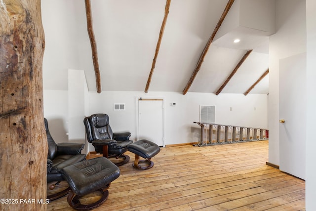 interior space featuring lofted ceiling with beams and light hardwood / wood-style flooring