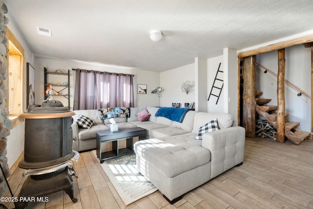 living room with a textured ceiling and light hardwood / wood-style flooring