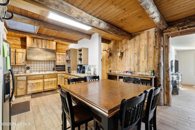 dining area with beamed ceiling, light hardwood / wood-style floors, and wooden ceiling