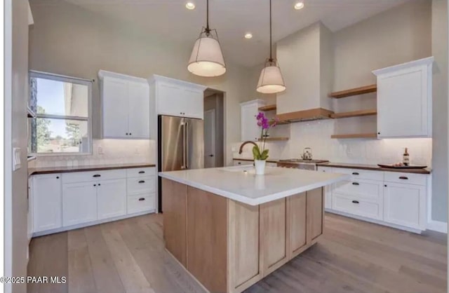 kitchen featuring tasteful backsplash, light wood-style floors, appliances with stainless steel finishes, and a sink