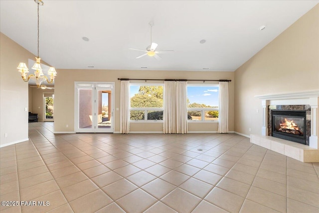 13375 N Iron Hawk Dr, Prescott, AZ 86305 - unfurnished living room featuring light tile patterned floors, high vaulted ceiling, ceiling fan with notable chandelier, a high end fireplace, and baseboards