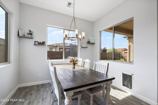 dining area featuring hardwood / wood-style floors and a chandelier