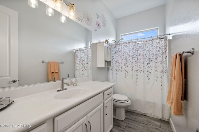 full bathroom featuring hardwood / wood-style floors, vanity, shower / tub combo, and toilet