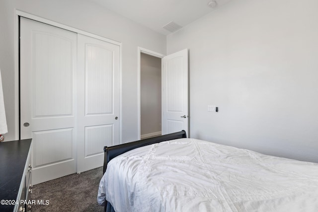 bedroom featuring dark colored carpet and a closet