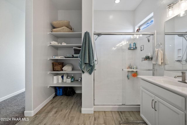 bathroom featuring wood-type flooring, vanity, and a shower with door