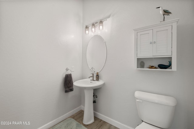 bathroom with hardwood / wood-style flooring and toilet