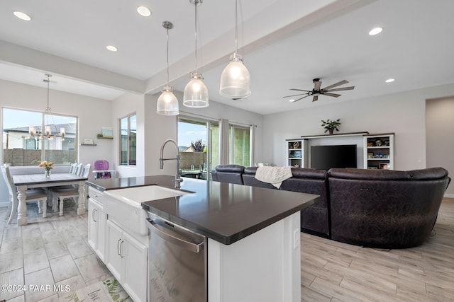 kitchen with a kitchen island with sink, ceiling fan with notable chandelier, sink, decorative light fixtures, and white cabinetry