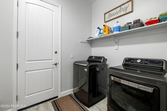 washroom featuring washer and dryer and light hardwood / wood-style floors