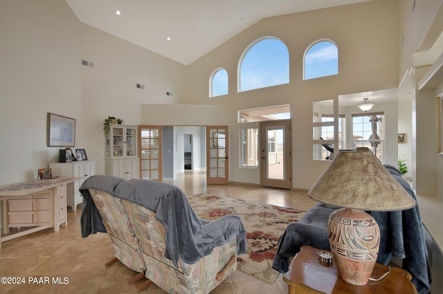 tiled living room with french doors and high vaulted ceiling