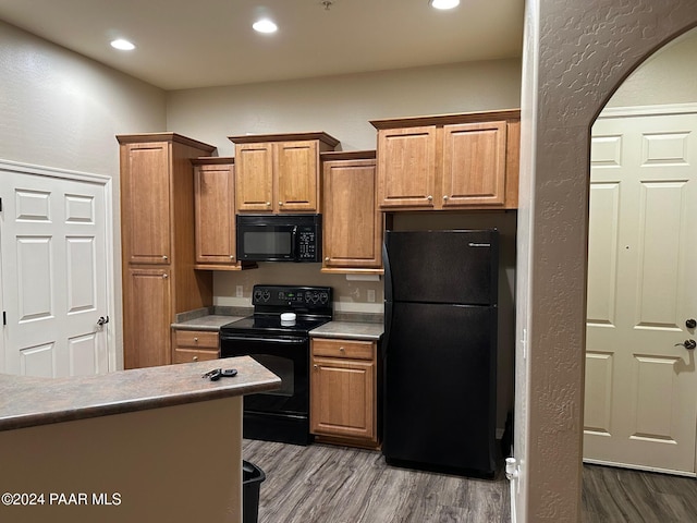 kitchen featuring black appliances and hardwood / wood-style flooring