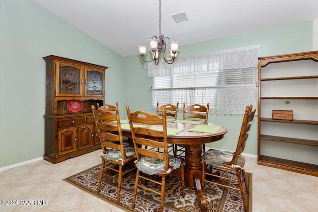 tiled dining space with vaulted ceiling and an inviting chandelier