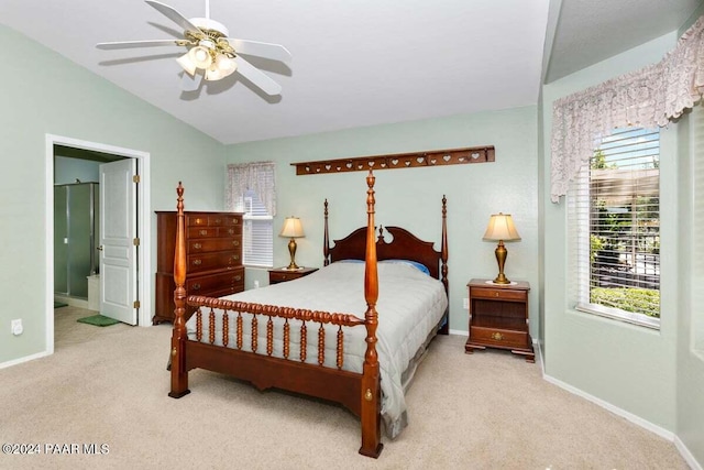 bedroom with ensuite bathroom, ceiling fan, light colored carpet, and vaulted ceiling