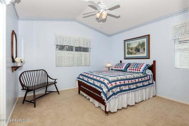 carpeted bedroom with ceiling fan and vaulted ceiling