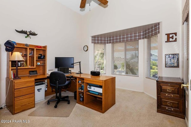 carpeted office with ceiling fan and high vaulted ceiling