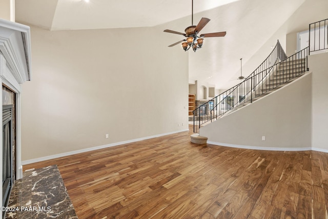 unfurnished living room with hardwood / wood-style floors, high vaulted ceiling, and ceiling fan