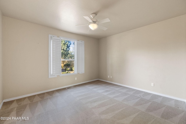 carpeted empty room featuring ceiling fan