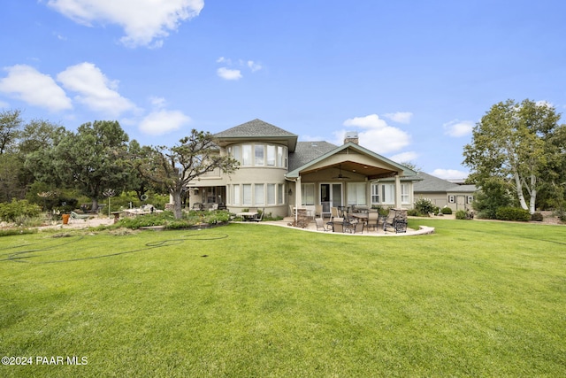 back of property with a lawn, ceiling fan, and a patio area