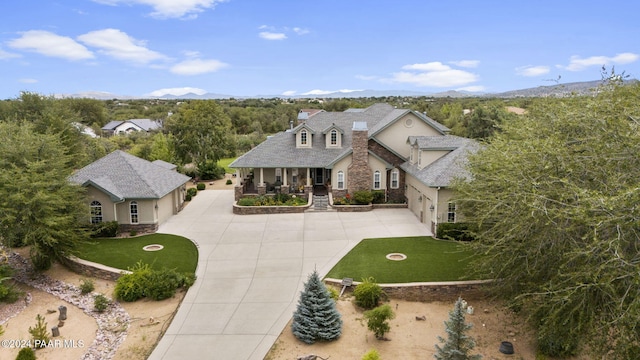 view of front of home featuring a mountain view, a front lawn, and a porch