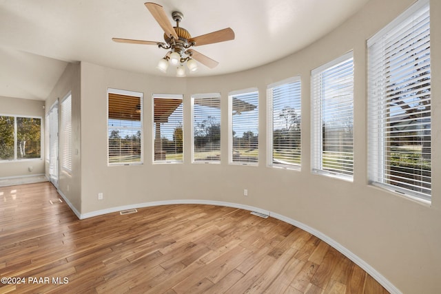 spare room featuring ceiling fan, a healthy amount of sunlight, and light hardwood / wood-style floors