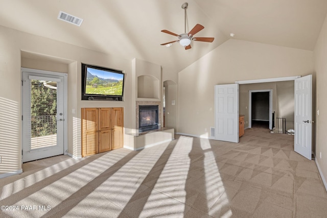 unfurnished living room with light colored carpet, high vaulted ceiling, and ceiling fan