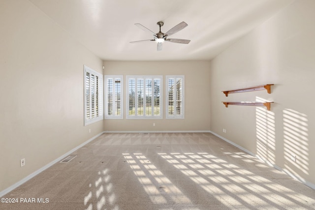 carpeted spare room featuring ceiling fan