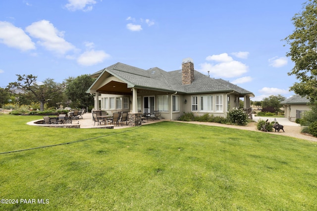 back of property with a patio area and a lawn