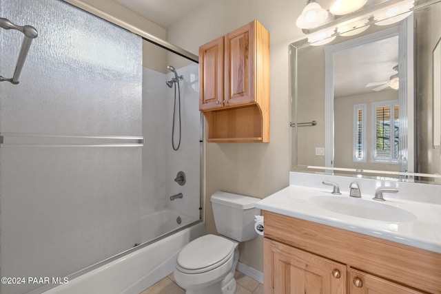 full bathroom featuring vanity, tile patterned floors, combined bath / shower with glass door, ceiling fan, and toilet