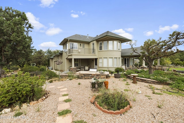 rear view of property featuring a balcony and a patio area