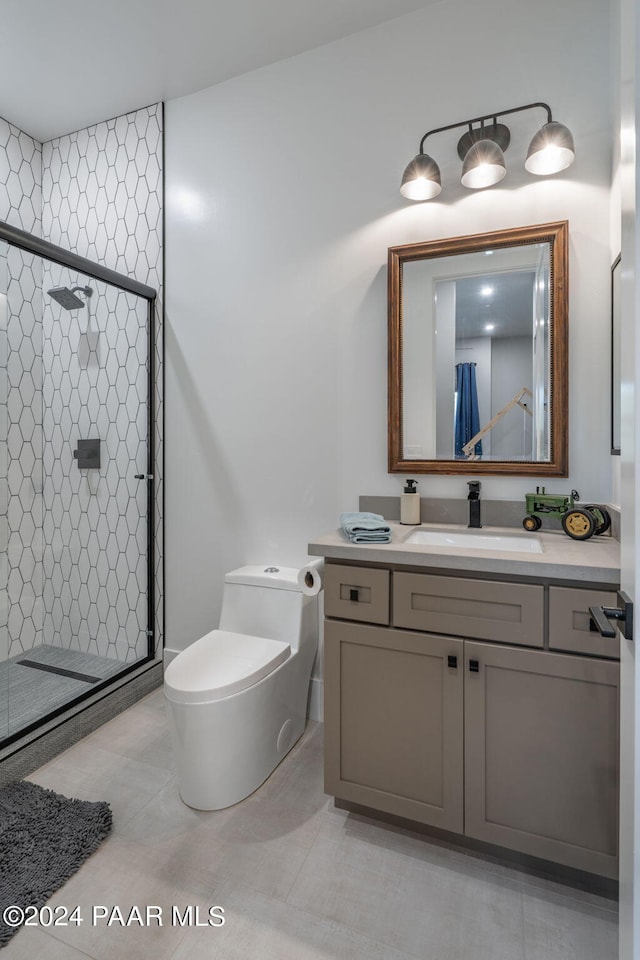 bathroom with tile patterned flooring, a shower with door, vanity, and toilet