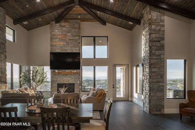 dining area with beam ceiling, wooden ceiling, a fireplace, and high vaulted ceiling