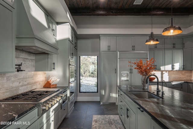 kitchen with beamed ceiling, custom range hood, sink, and tasteful backsplash