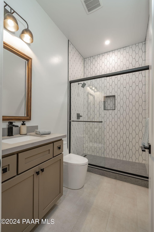 bathroom featuring vanity, toilet, and a shower with door